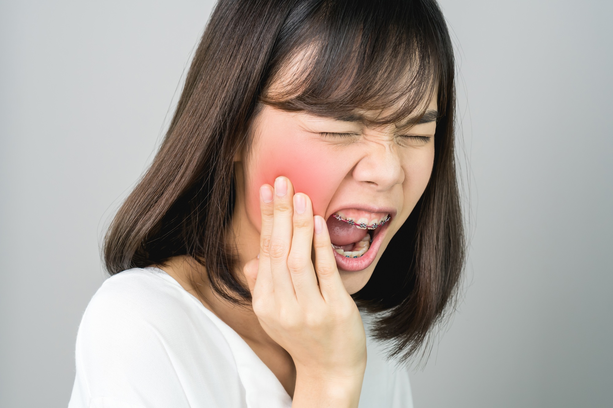 Asian girl in white casual dress Show off the toothache